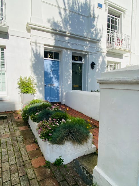 The front garden of the property features a narrow brick pathway leading to a blue front door with the number 78. The garden bed along the pathway contains well-maintained, lush green plants and a var
